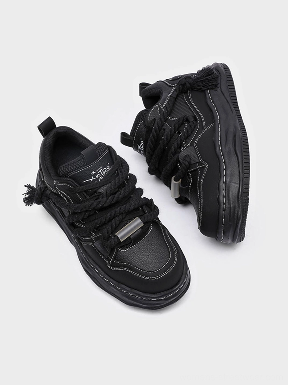 Black elevated streetwear sneakers with sculpted platform base decorative heel detail and tonal upper