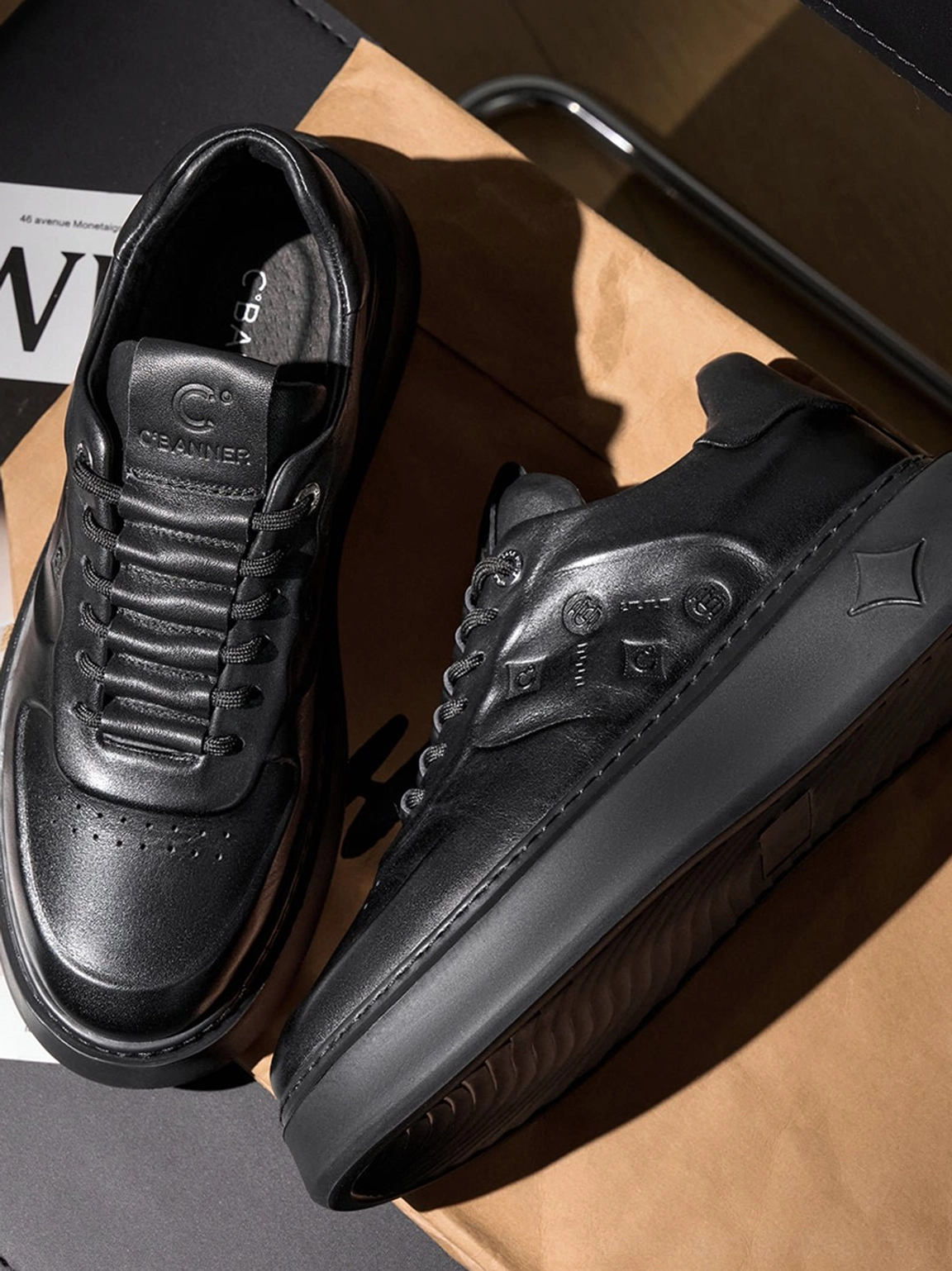 Detailed overhead view of black embossed platform low-top sneakers showing textured vamp and sculpted sole