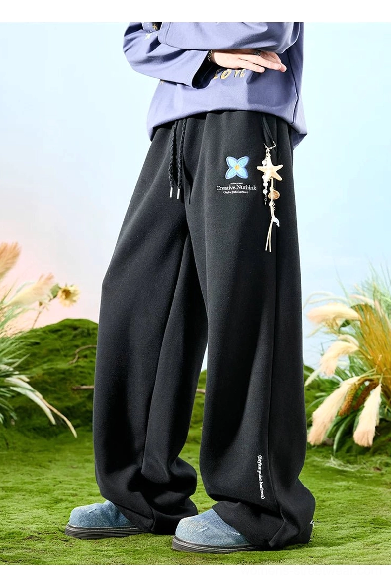 Black embroidered floral drawstring wide-leg sweatpants with blue butterfly motif and removable starfish charm