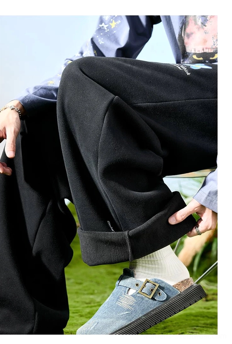 Close-up of black embroidered wide-leg streetwear sweatpants showing soft fabric, roomy leg opening, and cuff styling