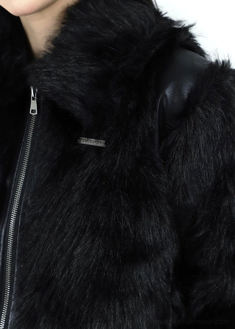 Close-up detail of the black faux fur bomber jacket stand collar, metal front zipper, shoulder panel, and chest plaque