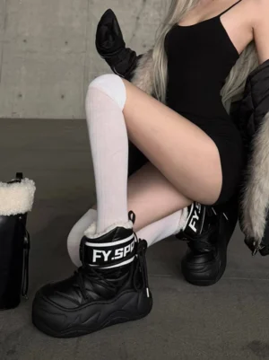 Model wearing black chunky faux fur moon boots with white thigh-high socks in an industrial winter streetwear outfit