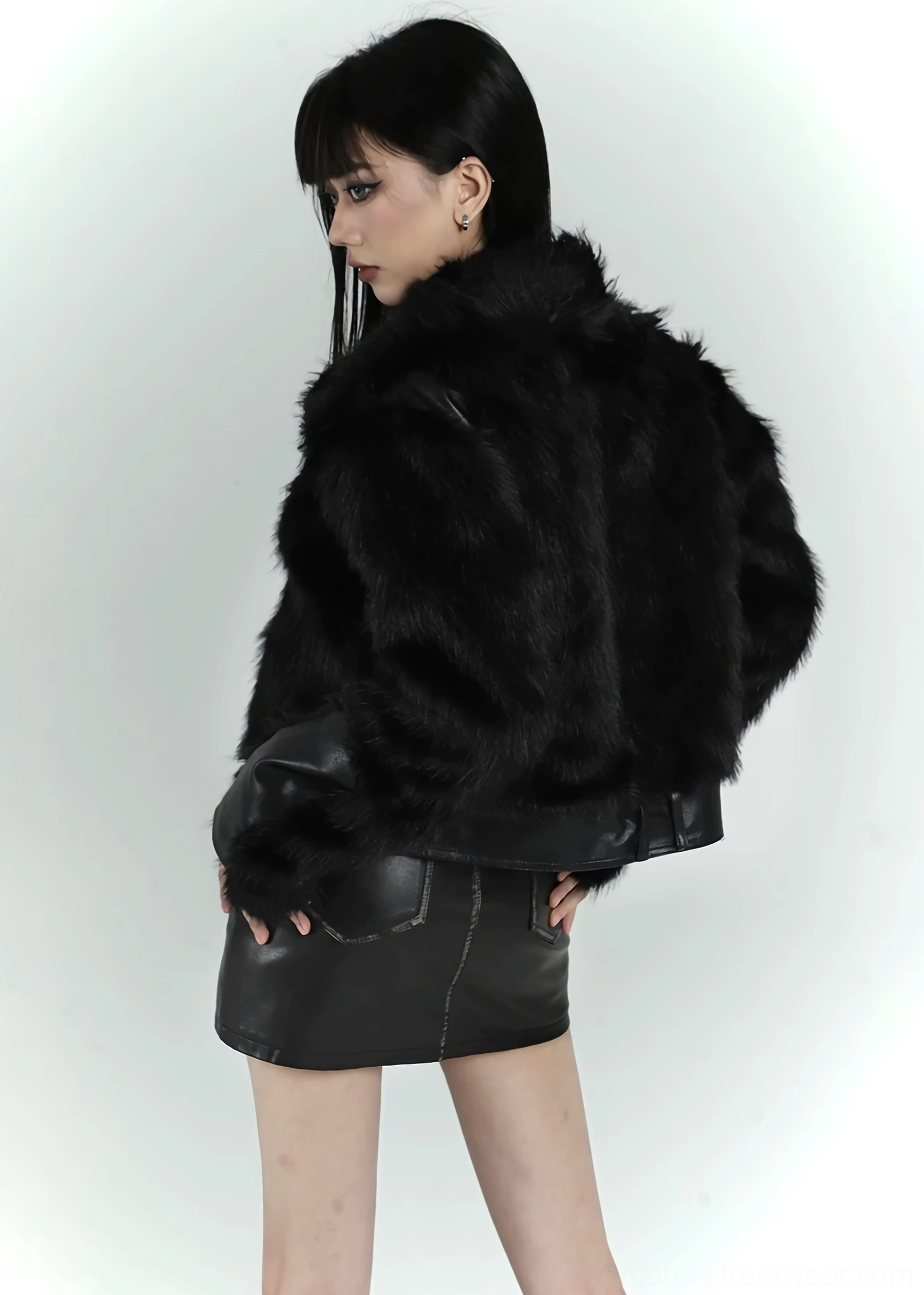 Back three-quarter view showing the fluffy full-back silhouette of a black faux fur cropped bomber jacket