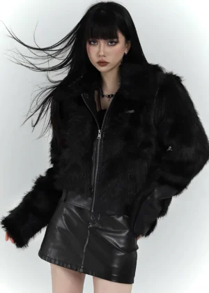 Front view of a black faux fur cropped bomber jacket styled with a black leather-look mini skirt for a Y2K goth outfit