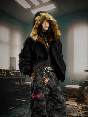Female model wearing a black faux fur trim hooded bomber jacket with camo cargo pants in an oversized Seoul streetwear outfit
