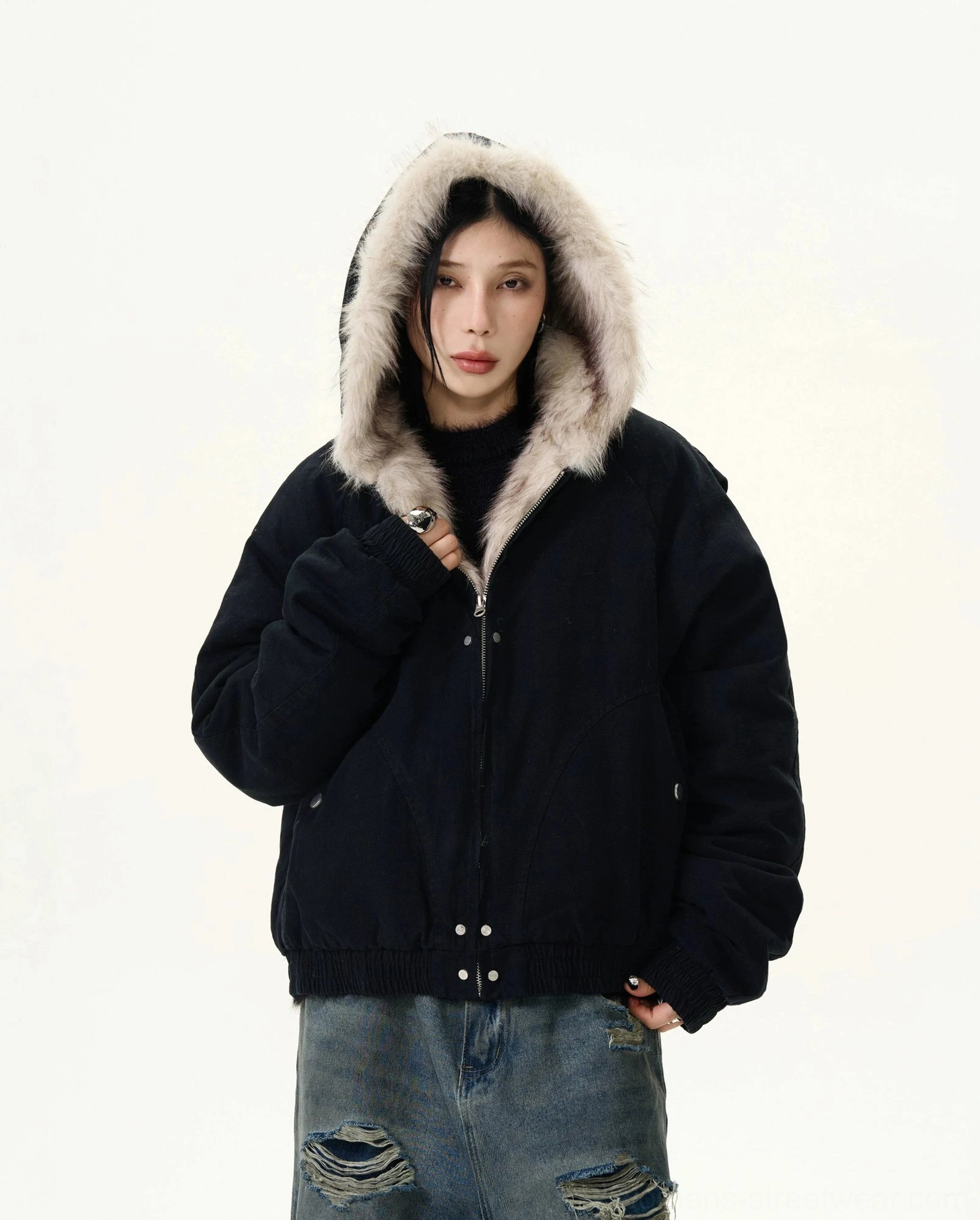 Black faux fur trim hooded cropped bomber jacket front view with hood up styled with ripped baggy denim