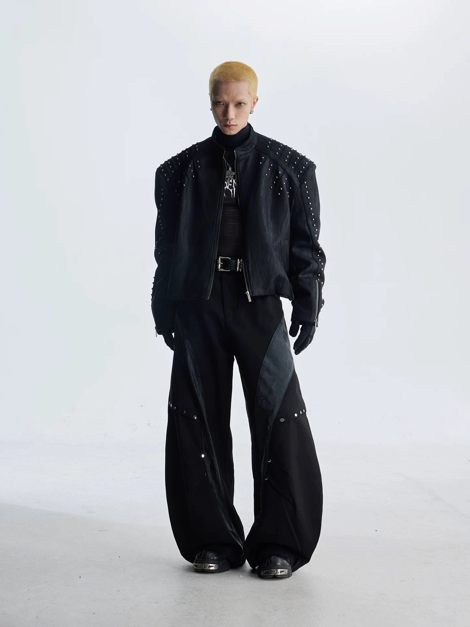 Full front view of black faux leather studded moto jacket with stand collar front zipper and structured shoulders
