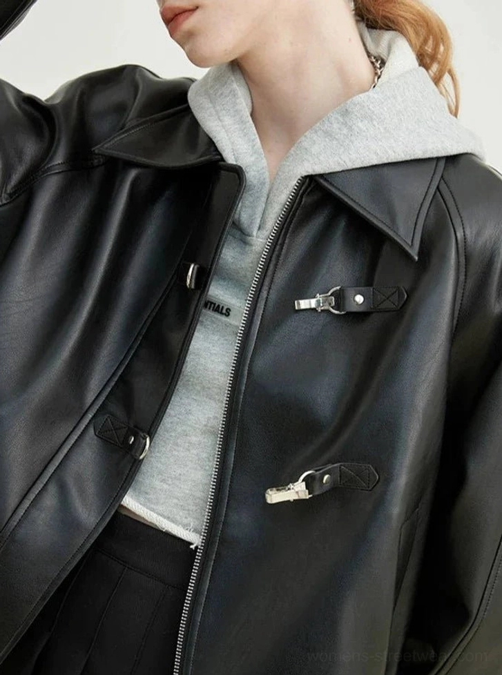Close-up detail of black faux leather streetwear jacket with silver metal toggle fasteners front zipper and tailored seams