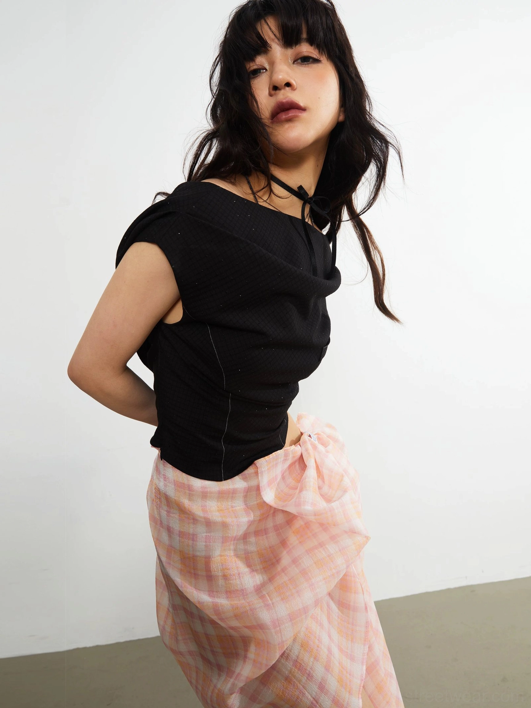 Black fitted asymmetric cropped knit top back-side view with open back contrast stitching and Seoul streetwear styling