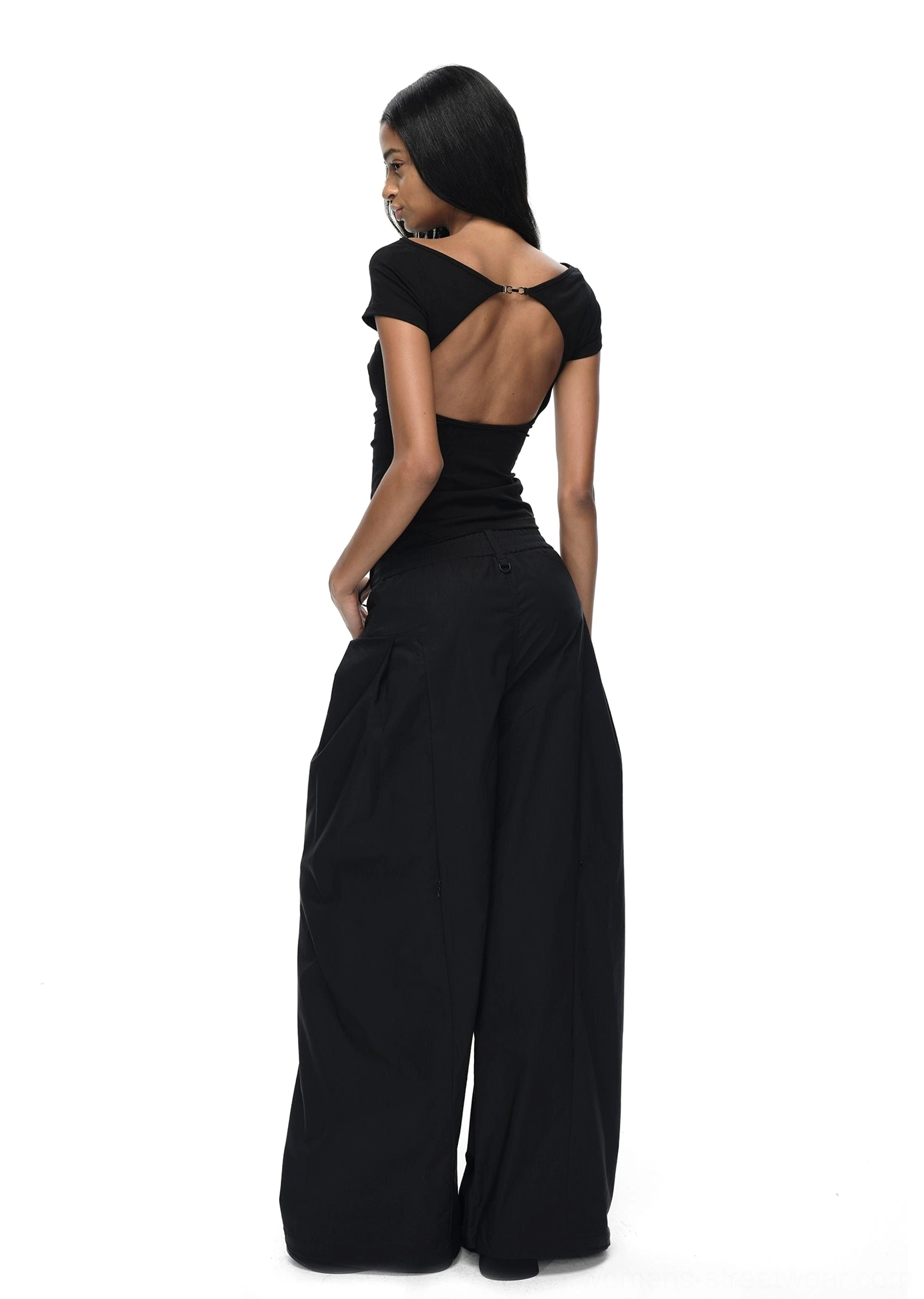 Black fitted backless short-sleeve streetwear T-shirt with a dramatic open back styled with black wide-leg trousers