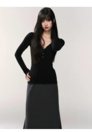 Close front view of a slim fit black buttoned V-neck henley long sleeve knit top with a sleek body-skimming silhouette