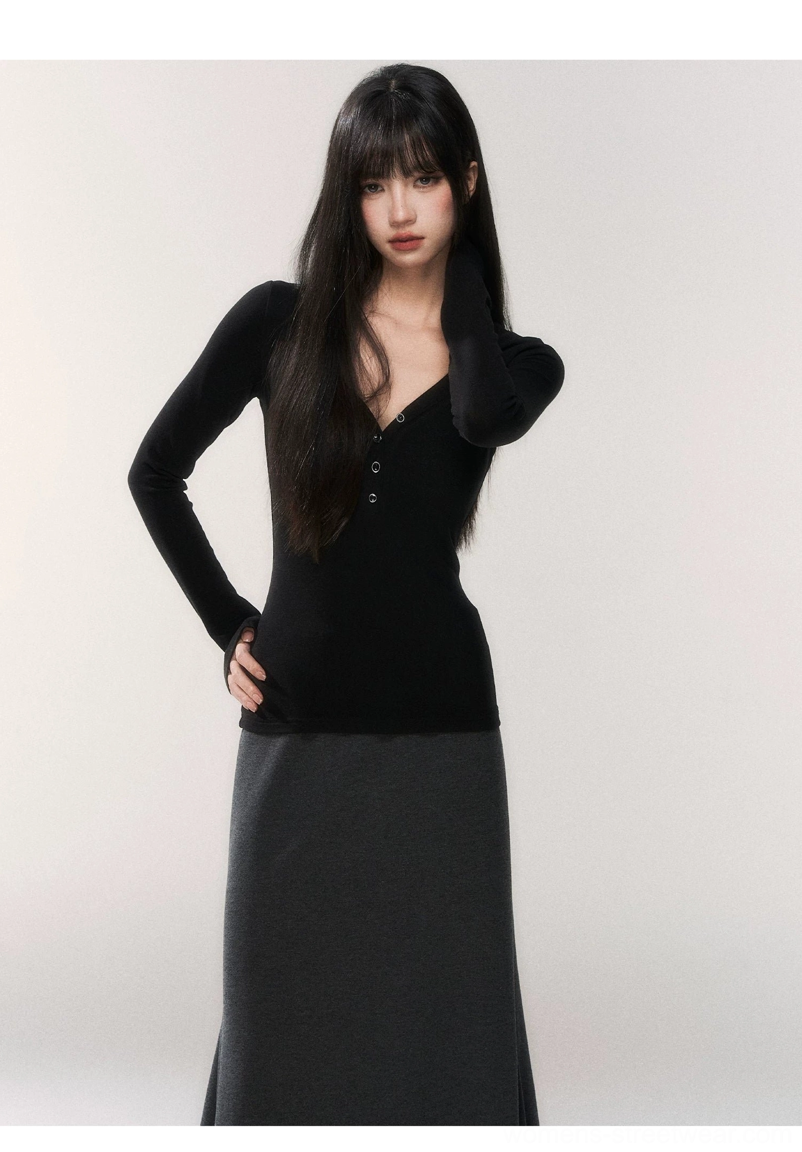 Close front view of a slim fit black buttoned V-neck henley long sleeve knit top with a sleek body-skimming silhouette