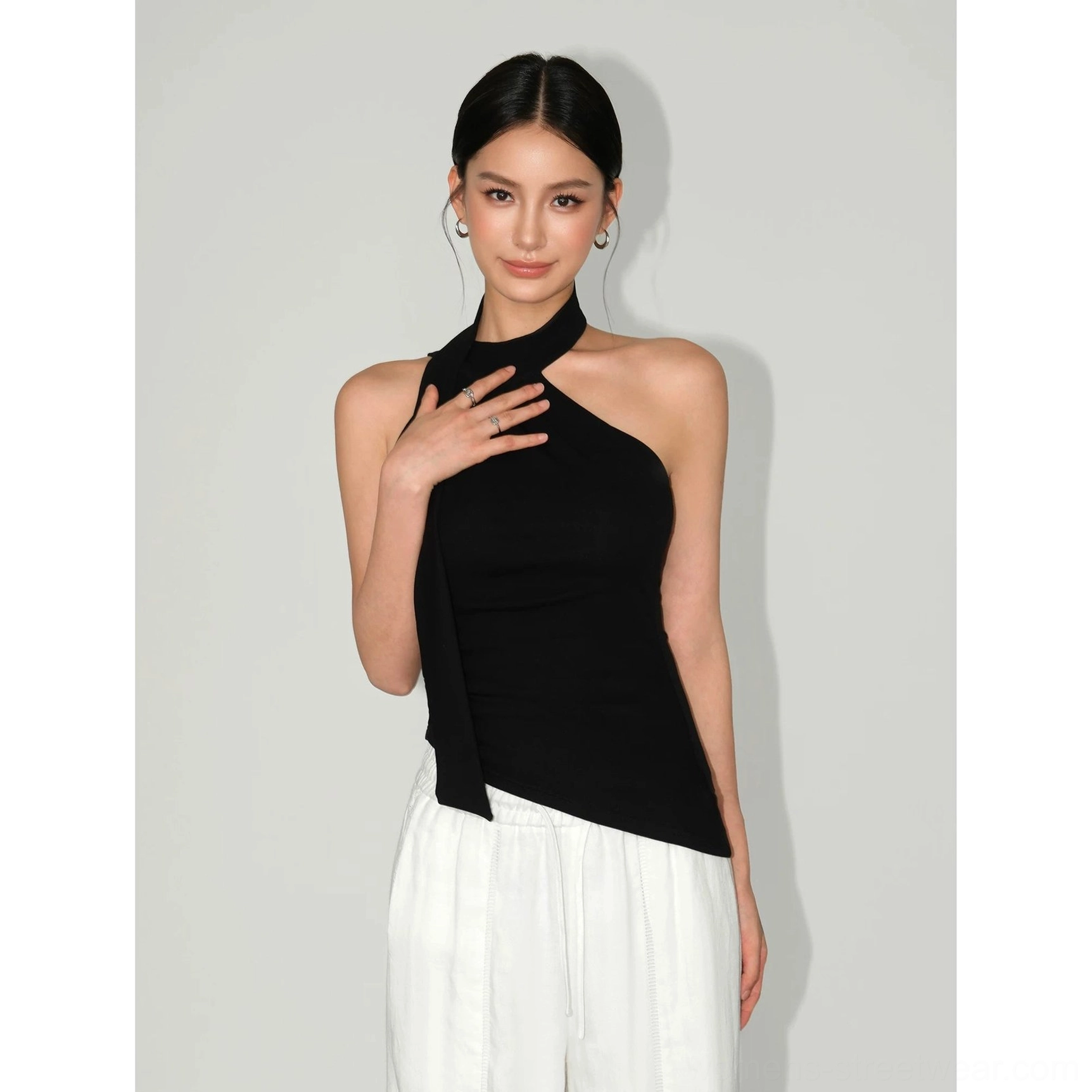 Black fitted halter knit top with asymmetric hem and draped neckline for refined avant-garde streetwear outfits
