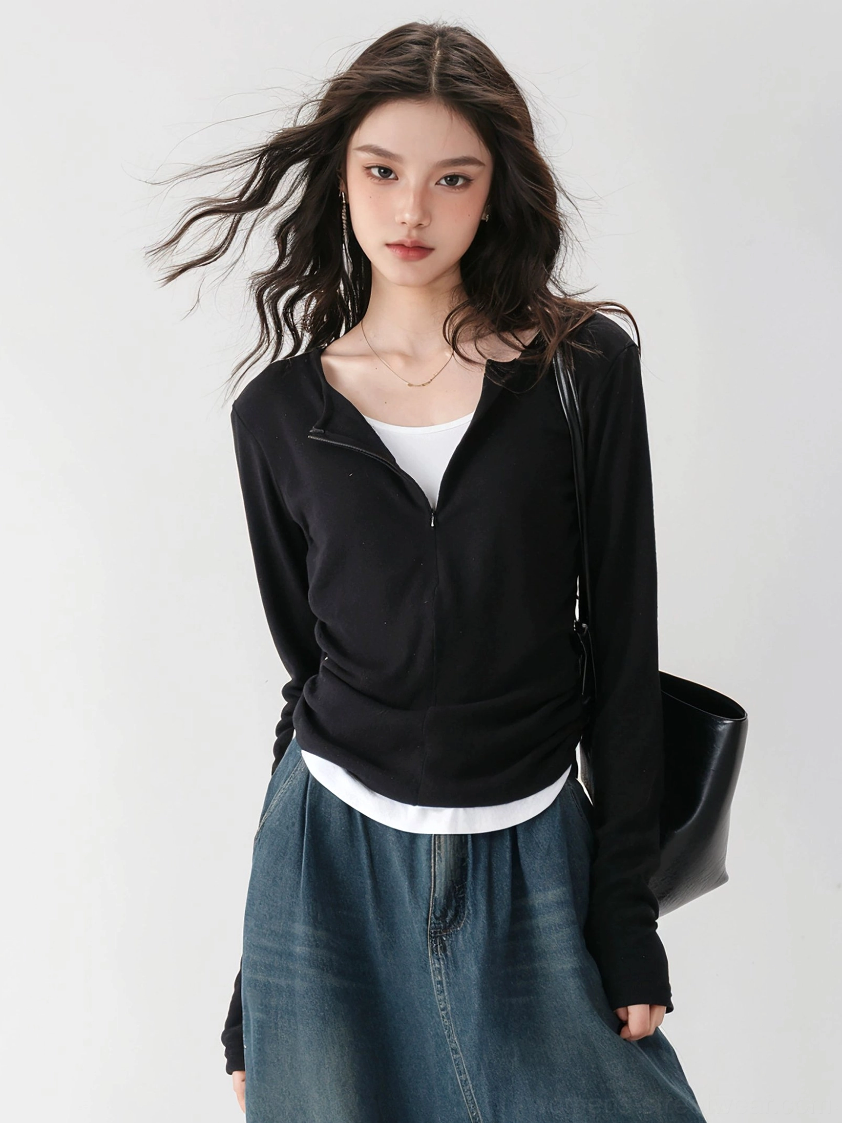 Black fitted ribbed knit streetwear top with long sleeves and exposed white layered hem shown in side front view