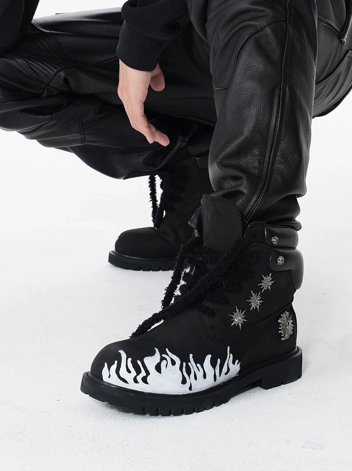 Black flame appliqué genuine leather lug sole combat boots with white flame graphic, padded collar, and thick black laces