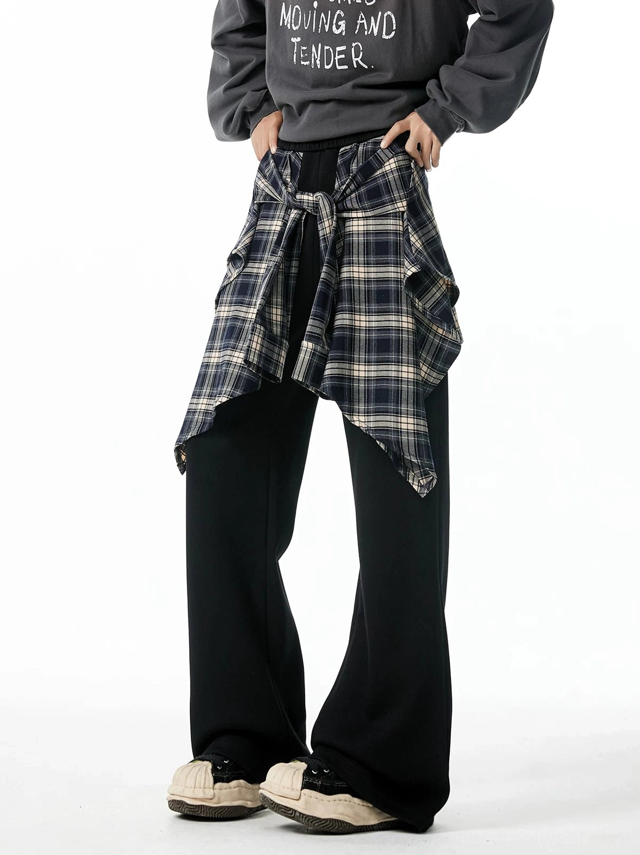 Black flannel wrap hybrid wide-leg jogger pants styled with a graphic sweatshirt and chunky sneakers from a front three-quarter view