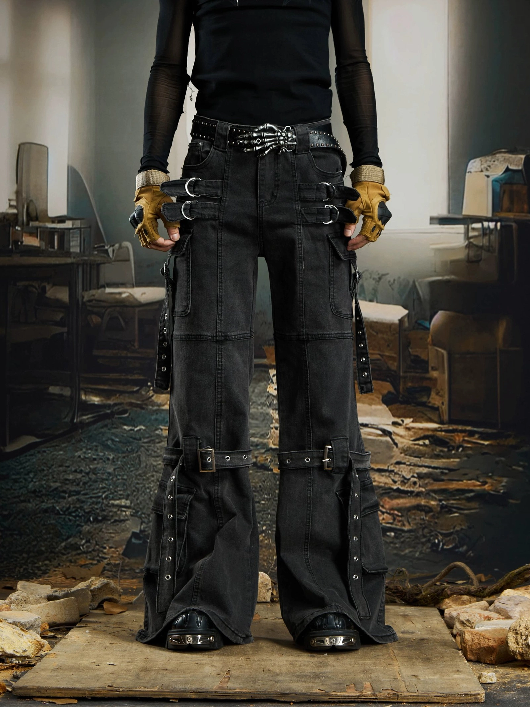 Full rear view of black flared cargo jeans with western-inspired metal belt details, side straps, utility pockets, and wide streetwear legs