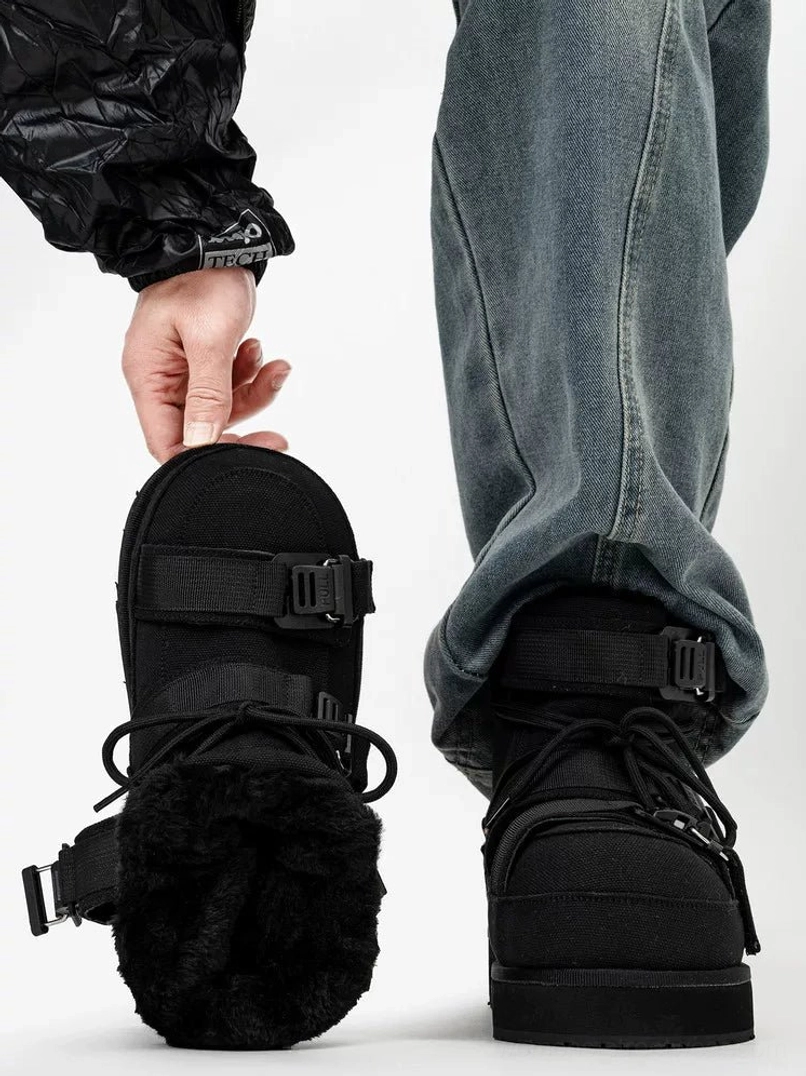 Black fleece-lined triple-buckle platform winter boots on foot, back view with one boot held up to display plush synthetic lining