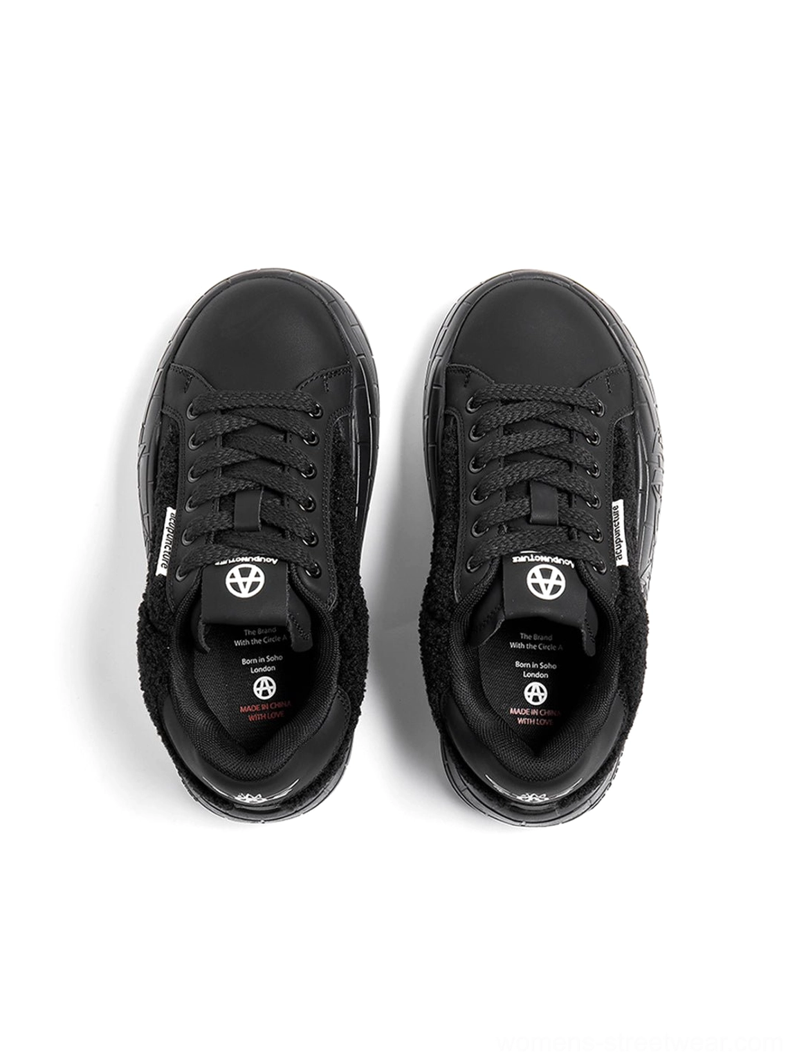 Top-down view of black fleece platform sneakers showing lace-up closure, tongue details, and shoe interiors