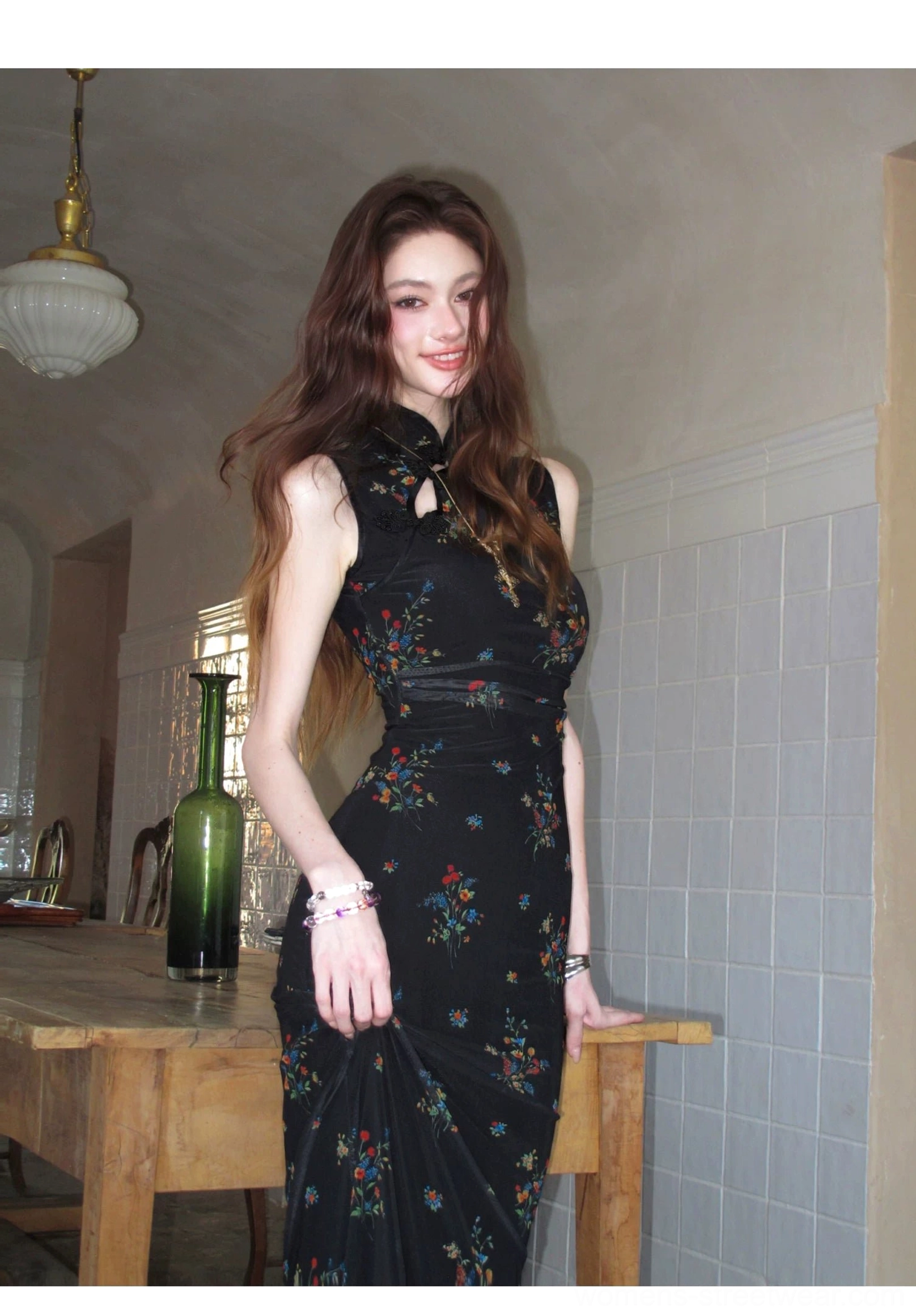 Three-quarter front view of a black floral cheongsam dress with waist gathering, sleeveless Mandarin collar, fitted shape, and elegant full-length hem
