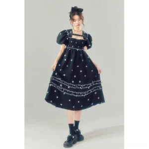 Front full-body view of a black floral embroidered square-neck puff sleeve midi dress styled with white crew socks and loafers