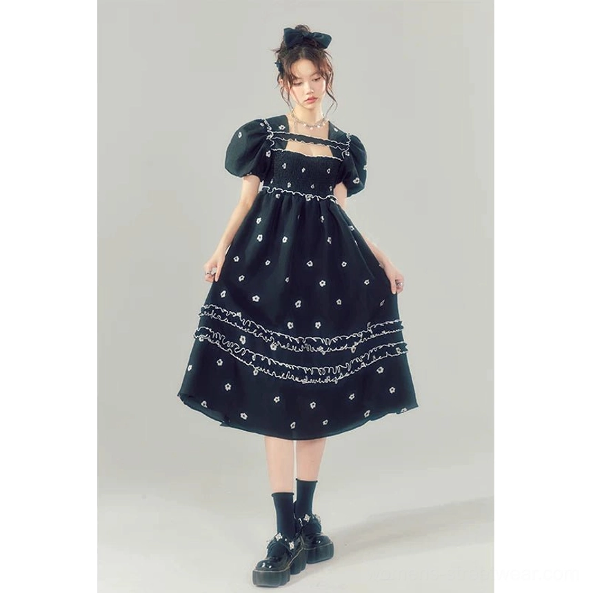 Front full-body view of a black floral embroidered square-neck puff sleeve midi dress styled with white crew socks and loafers