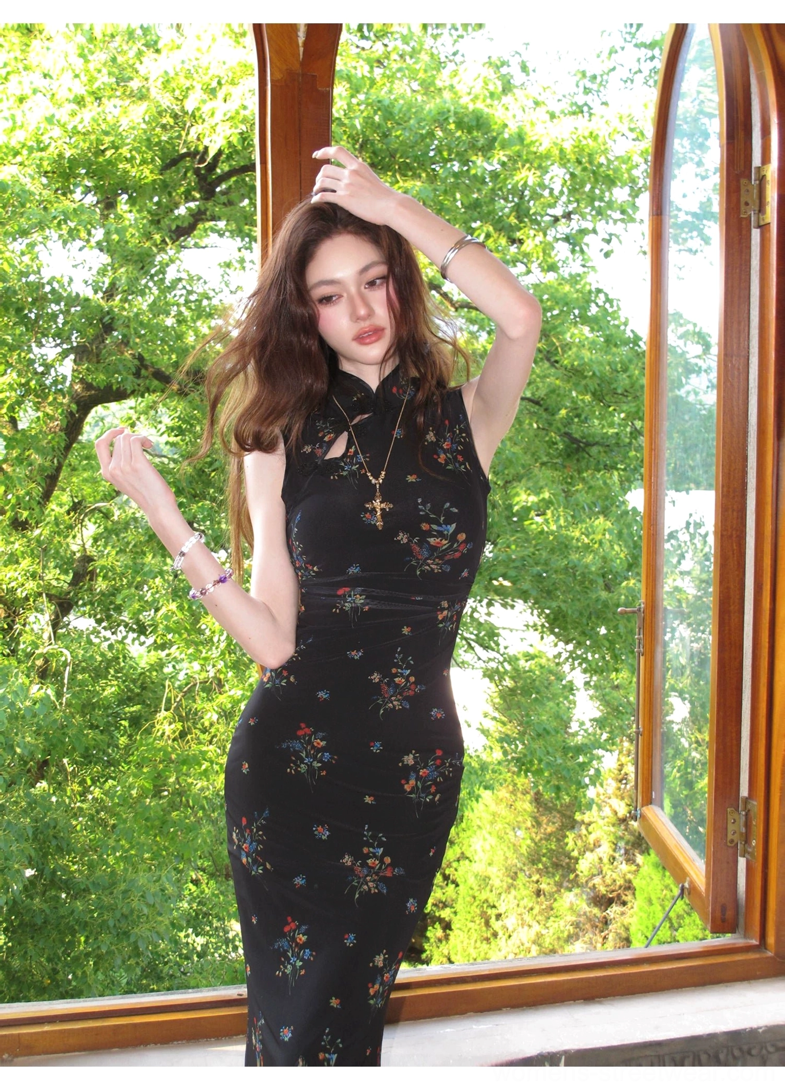 Dynamic three-quarter front view of a black floral sleeveless cheongsam dress featuring a Mandarin collar, keyhole cutout, waist shaping, and colorful flowers