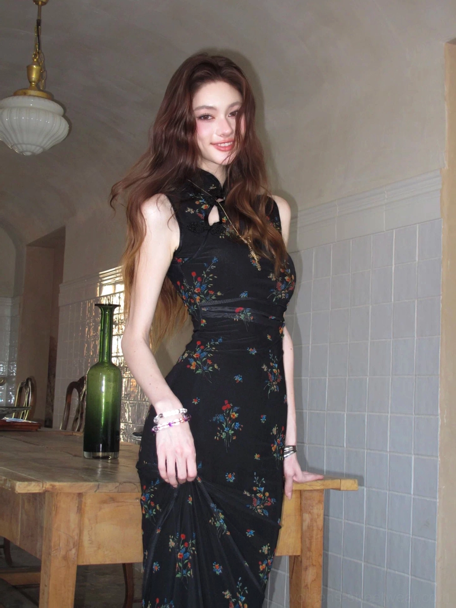 Three-quarter front view of a black floral sleeveless cheongsam maxi dress with Mandarin collar, keyhole neckline, fitted bodycon silhouette, and colorful bouquet print