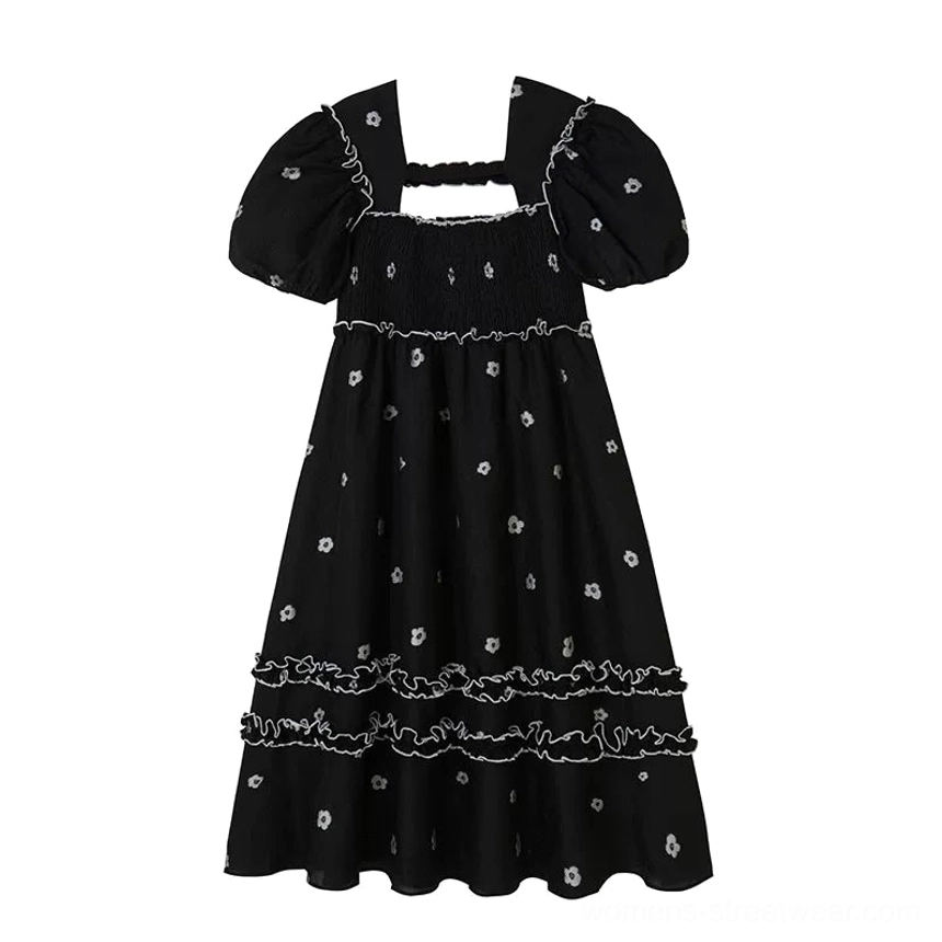 Flat lay view of a black floral embroidered square-neck puff sleeve midi dress with shirred bodice and tiered ruffle trim