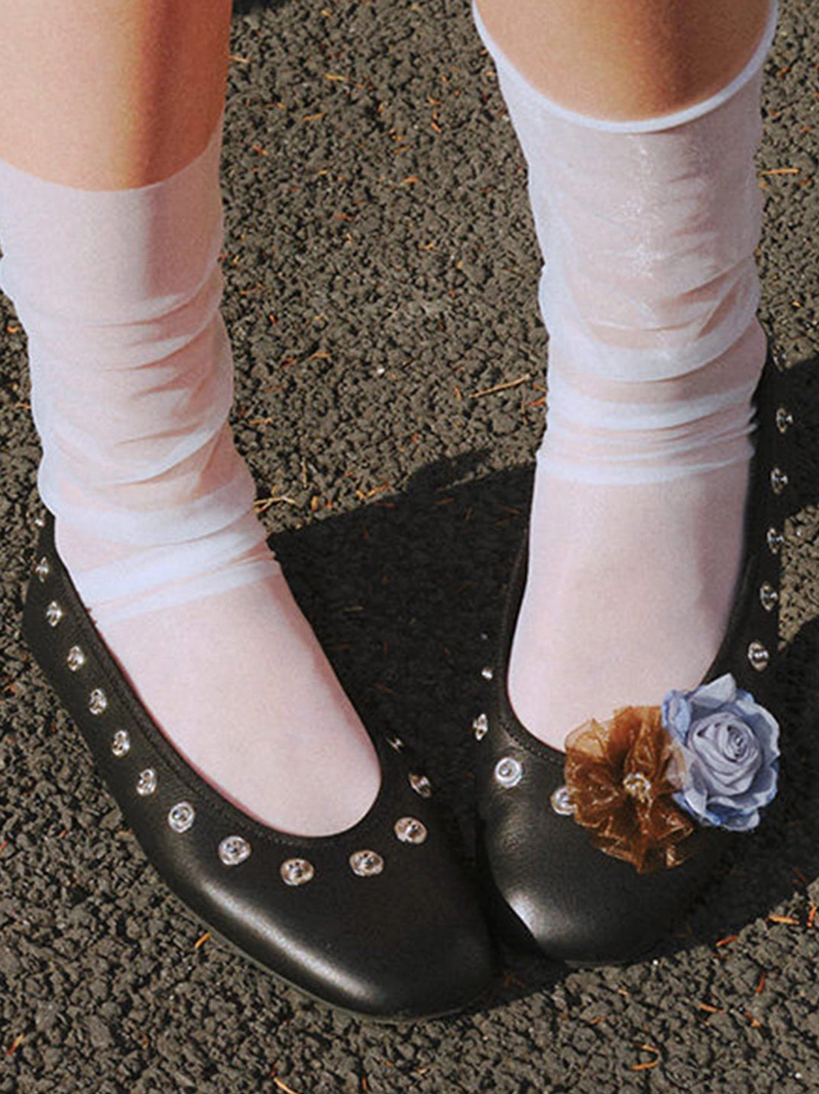 Black floral studded square-toe flats worn with sheer white ankle socks