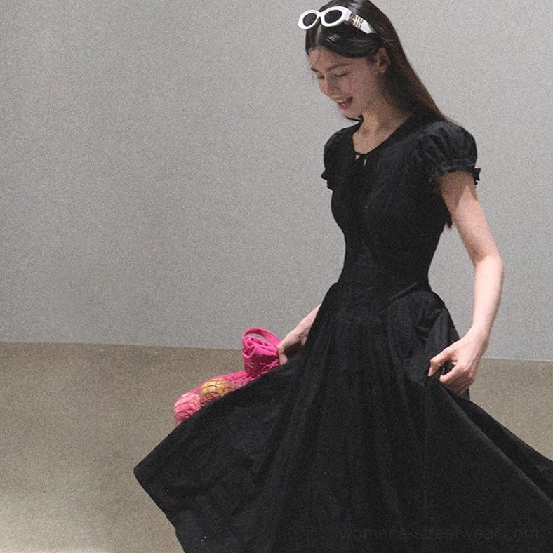 Black flutter sleeve long dress with defined waist and flowing skirt shown from a side angle