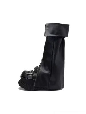 Black foldover buckle platform knee-high boots with matte leather upper, chain toe hardware, and chunky lug sole side view