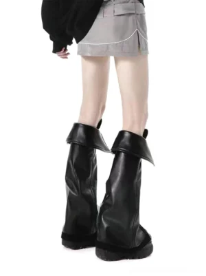 Back view of black foldover cuff platform knee-high boots worn on foot, showing tall shaft and thick ridged sole