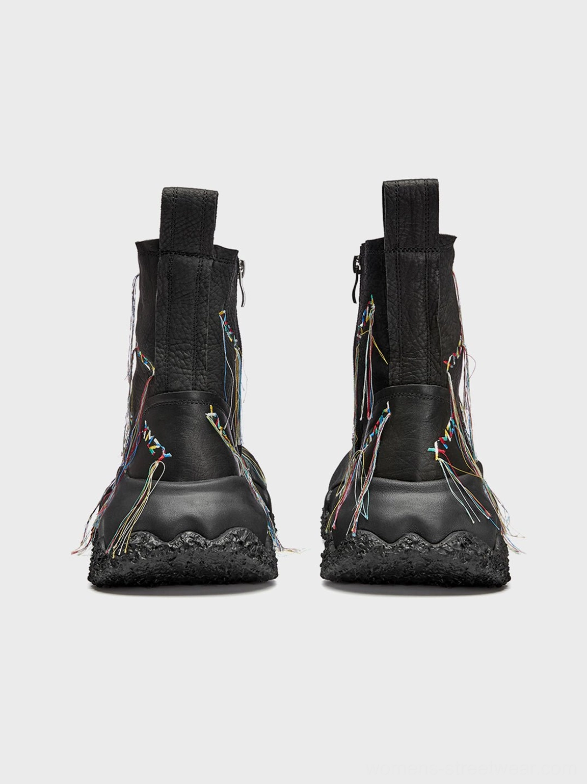Front-facing pair of black fringe western ankle boots with colorful geometric tassel decorations and thick treaded outsoles