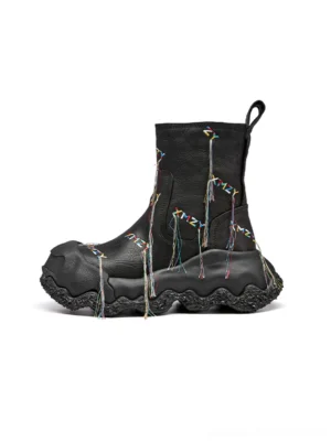 Black fringe western ankle boots side view with colorful geometric planet-inspired tassels, rear pull tab, and chunky treaded sole on white background