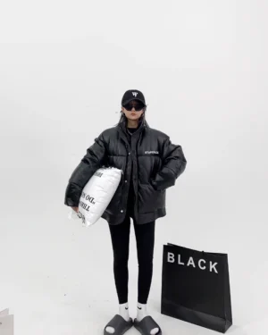 Black full-length minimalist streetwear leggings with a slim second-skin fit styled under a bright green puffer jacket and casual slide sandals