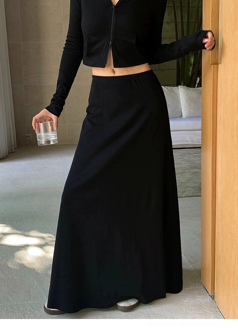 Black full-length stretch knit maxi skirt styled with a cropped black zip-up top for minimalist streetwear