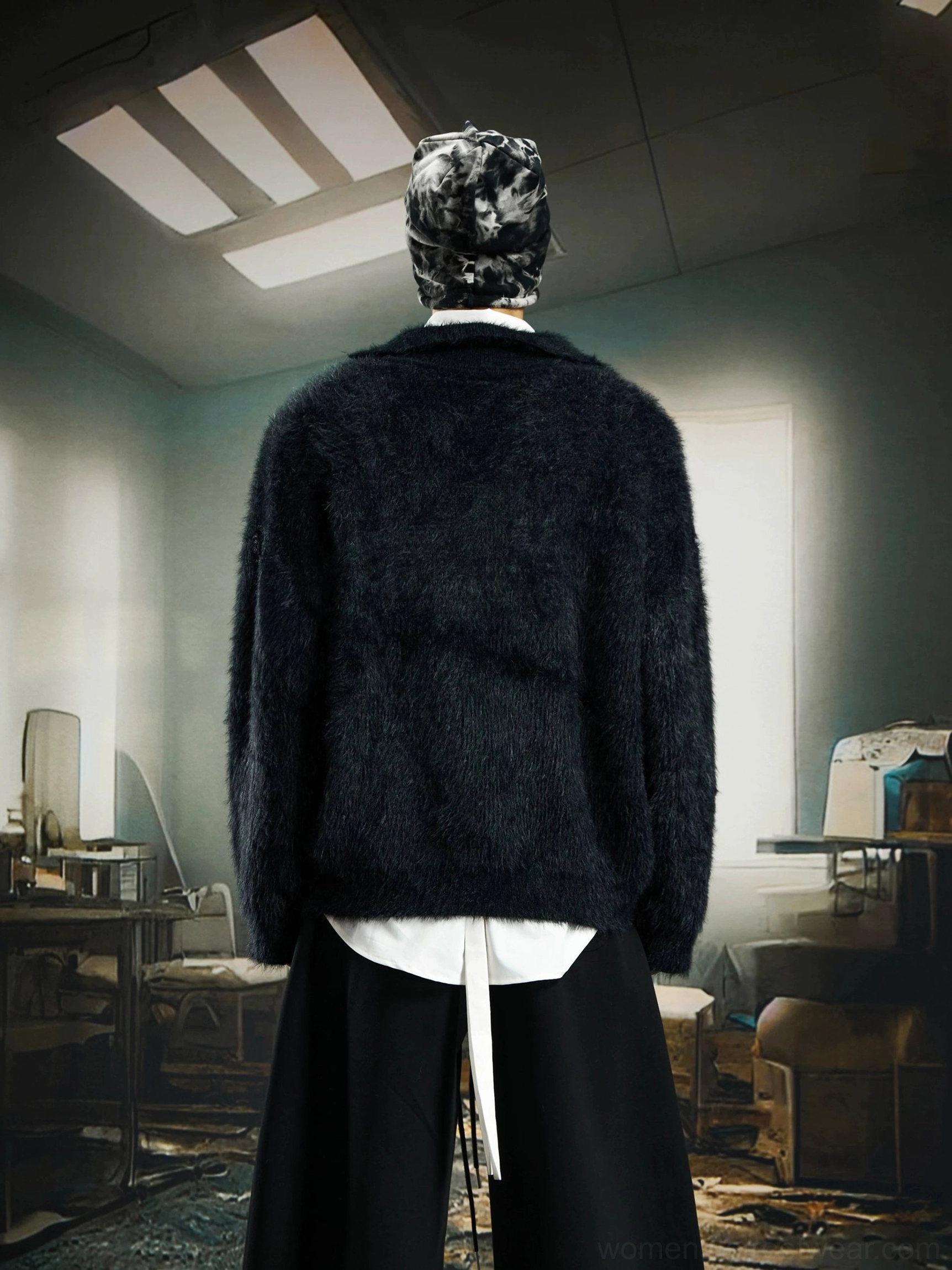 Black oversized fuzzy knit sweater shown from the back on a male model wearing a printed bucket hat with layered streetwear styling