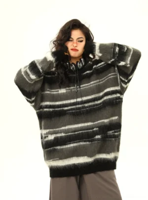 Black fuzzy gradient stripe oversized hooded knit sweater front view styled with gray wide leg pants