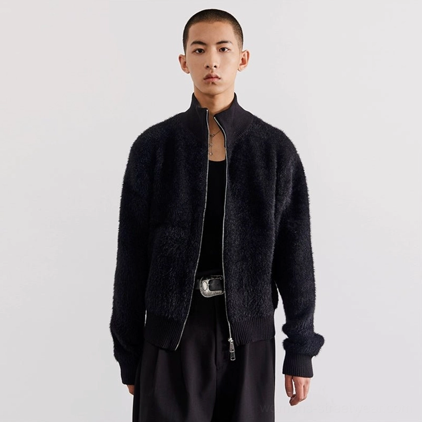 Black fuzzy stand-collar zip-up fleece cardigan worn with dark trousers in a clean minimalist streetwear outfit