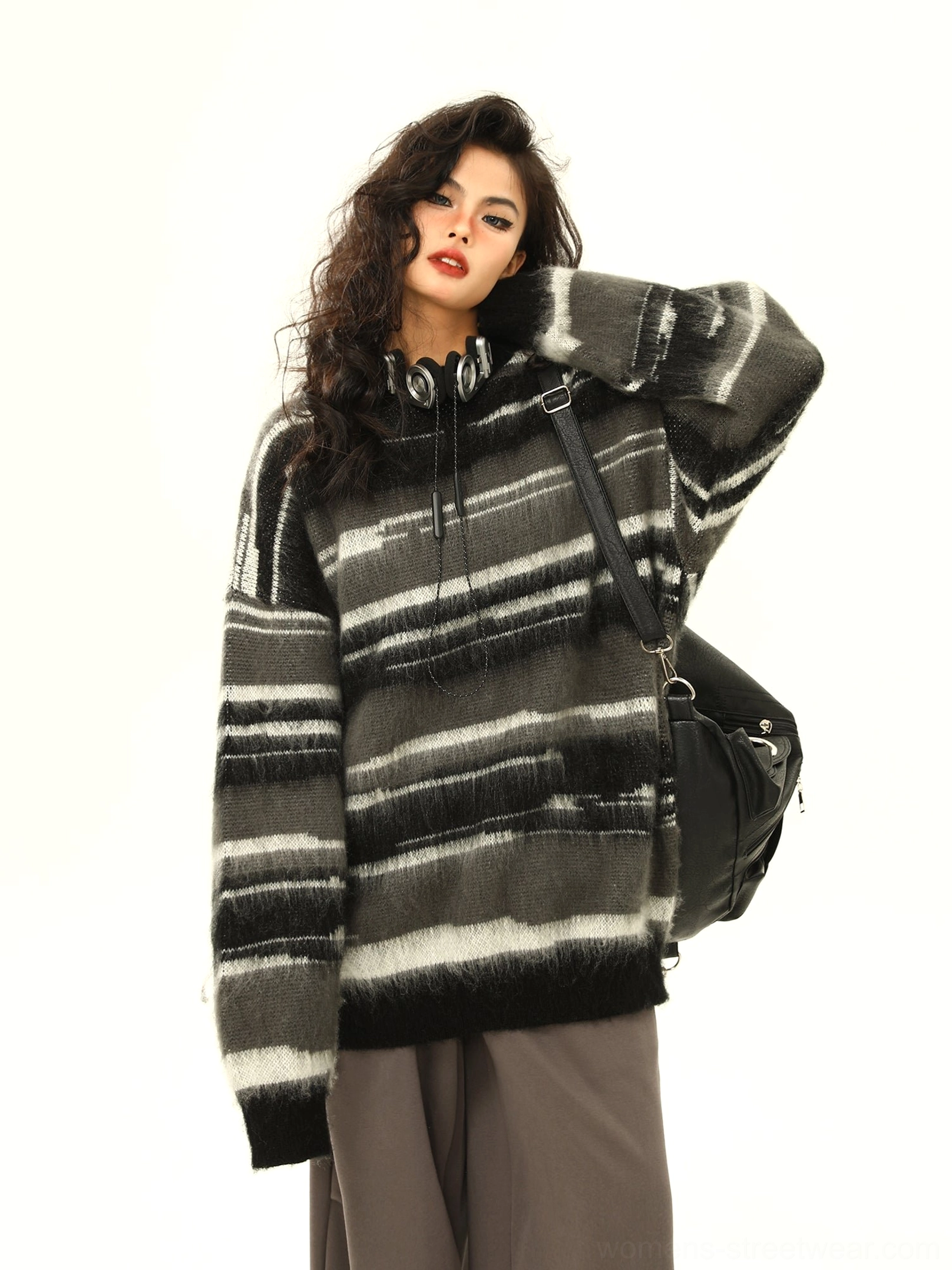 Black fuzzy striped oversized knit hoodie side front view showing ribbed cuffs and relaxed silhouette