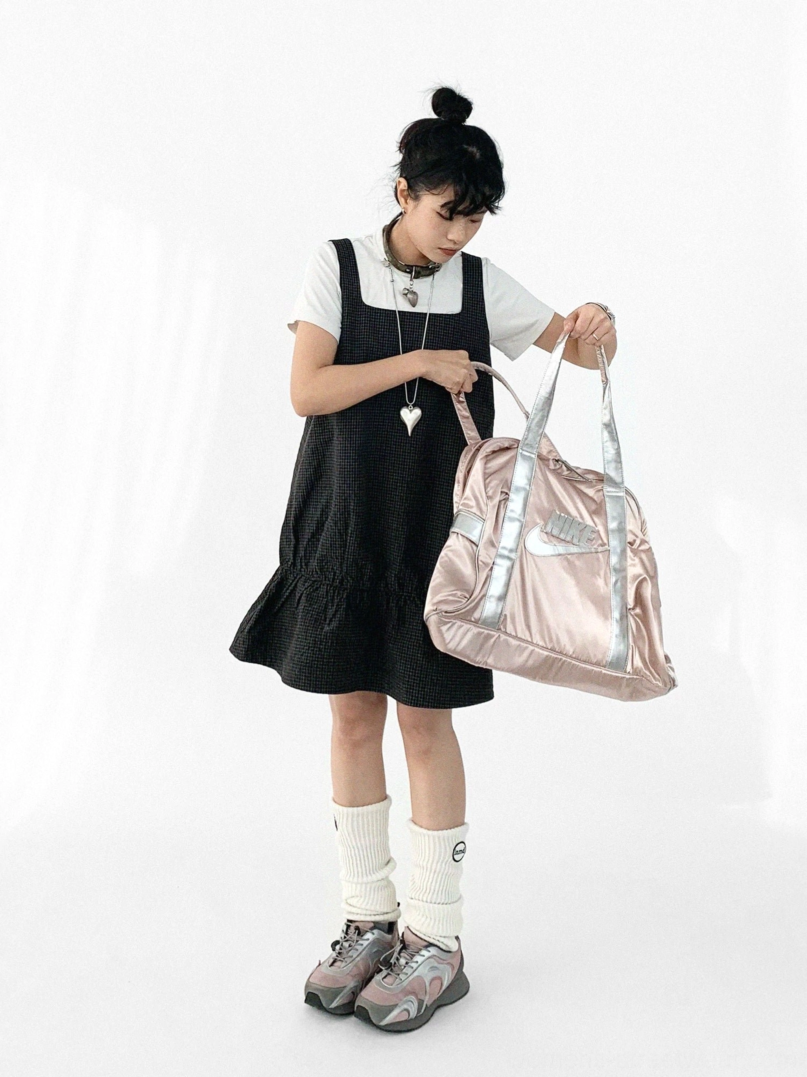 Black gingham ruffled pinafore mini dress front view layered over a white t shirt with sneakers