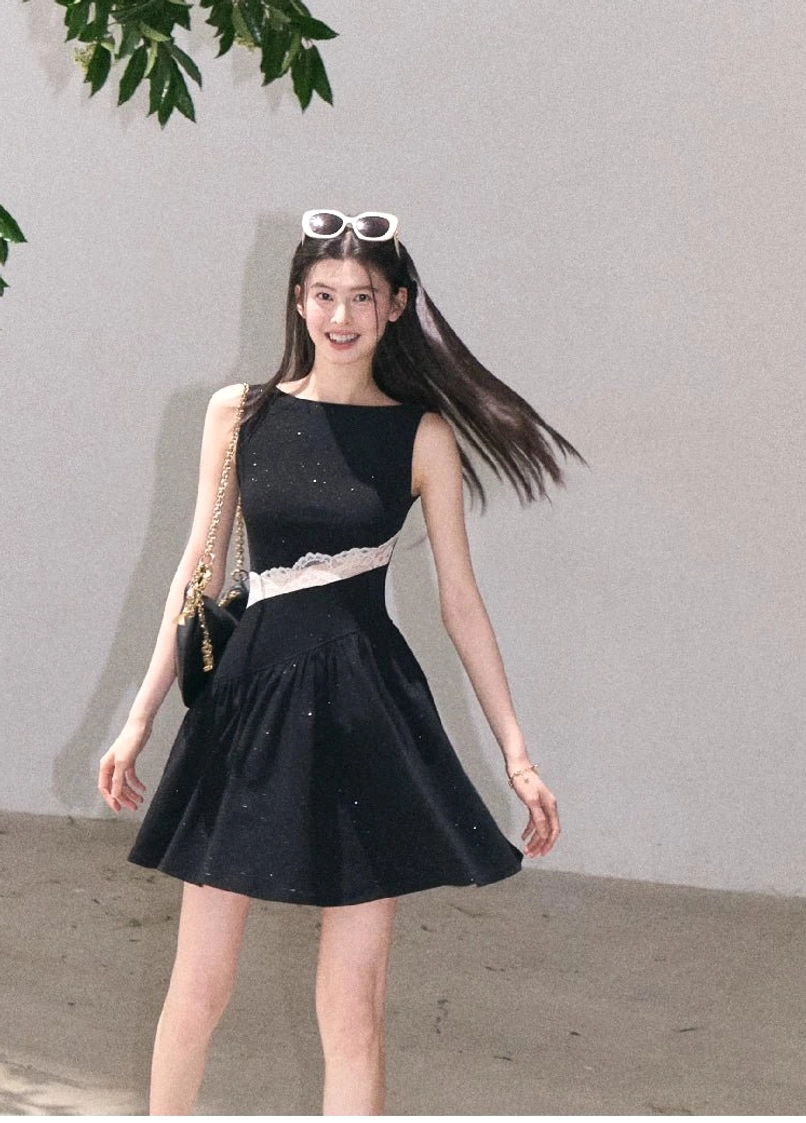 Black glitter asymmetrical lace waist mini dress with white sheer lace panel and flowing flared skirt in motion