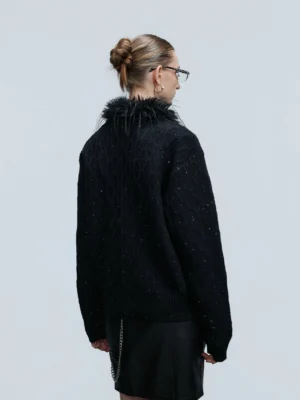Back view of black cropped glitter cable knit cardigan with textured twisted knit pattern and faux feather collar