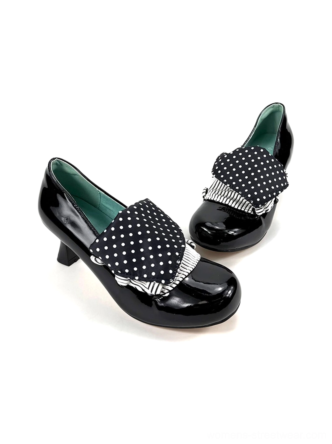 Overhead flat lay of black glossy patent pumps with layered polka dot bows, striped loops and dark green lining