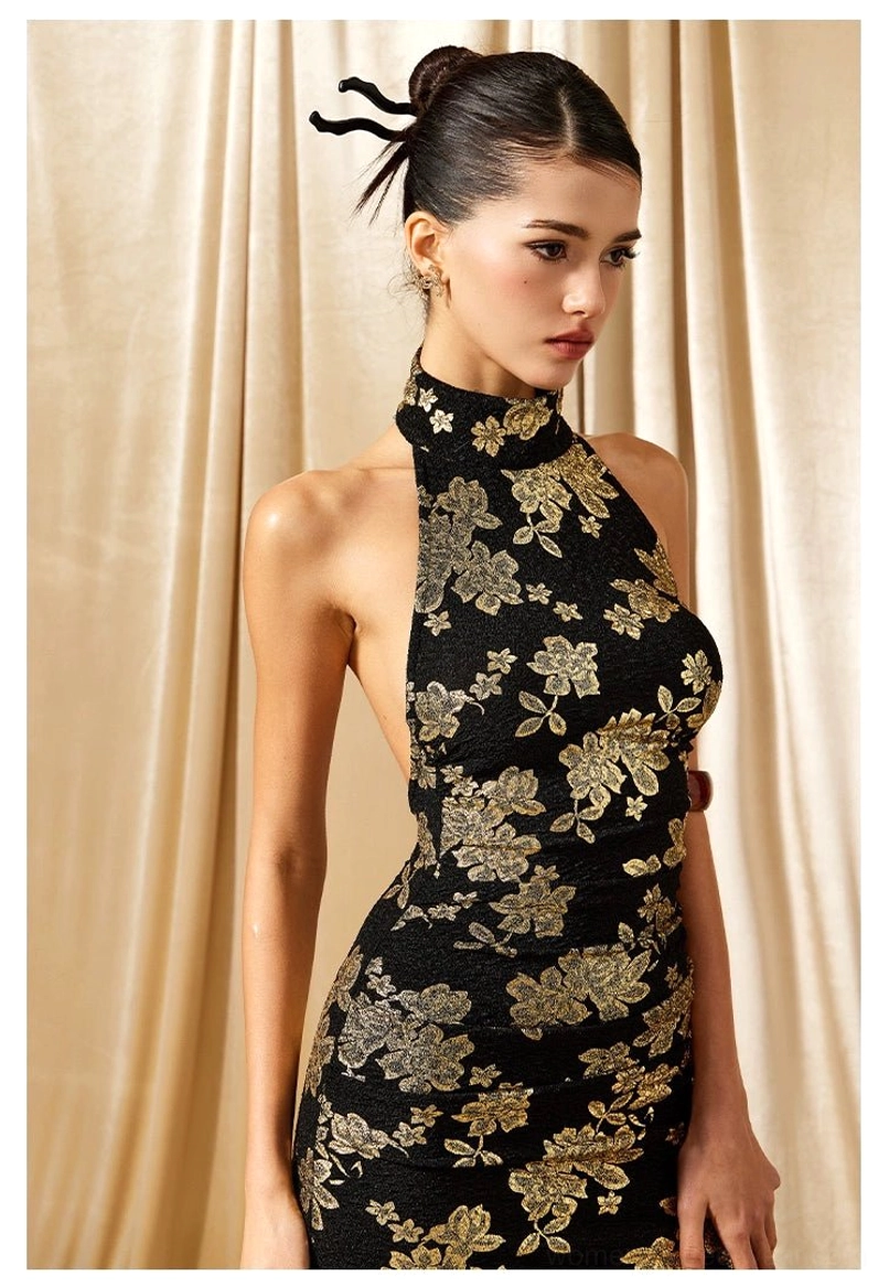 Close up view of the high halter collar and detailed gold floral print on a black cheongsam inspired maxi dress