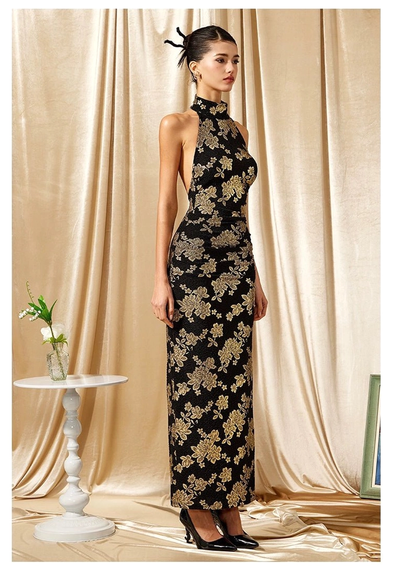 Three quarter view of a fitted black and gold halter maxi dress with mandarin collar and elegant floor length shape