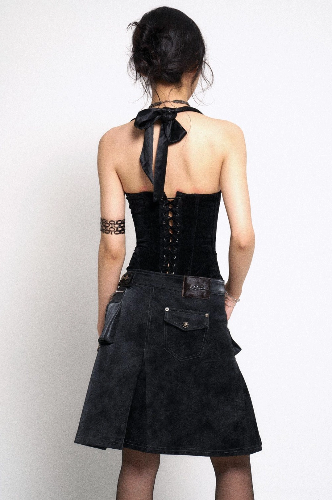 Black gothic asymmetrical mini skirt back view with weathered finish utility pocket and fitted silhouette