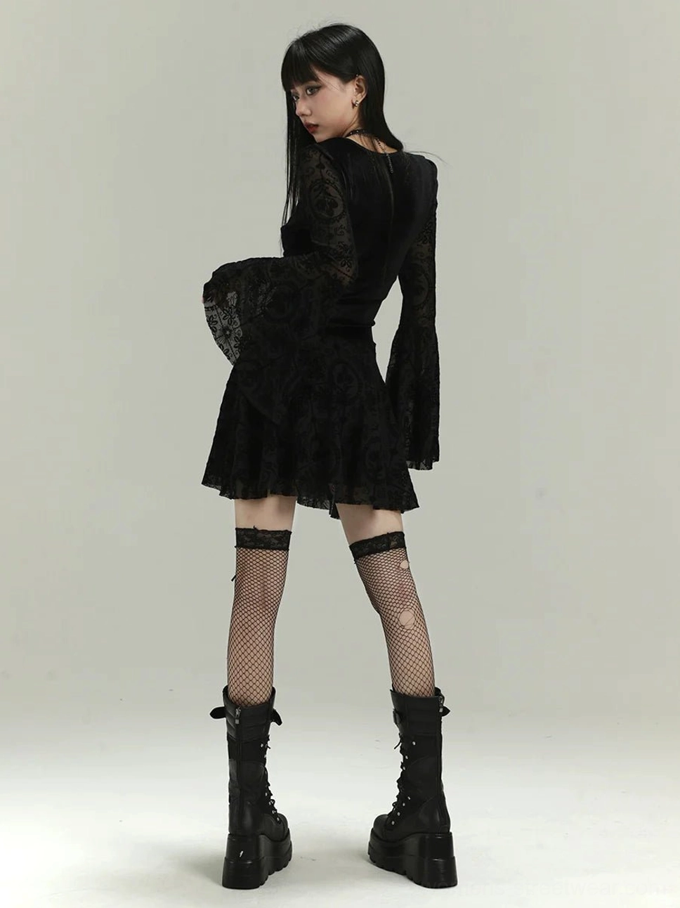 Back view of black gothic lace bell sleeve mini dress with sheer flocked lace sleeves and layered ruffle skirt