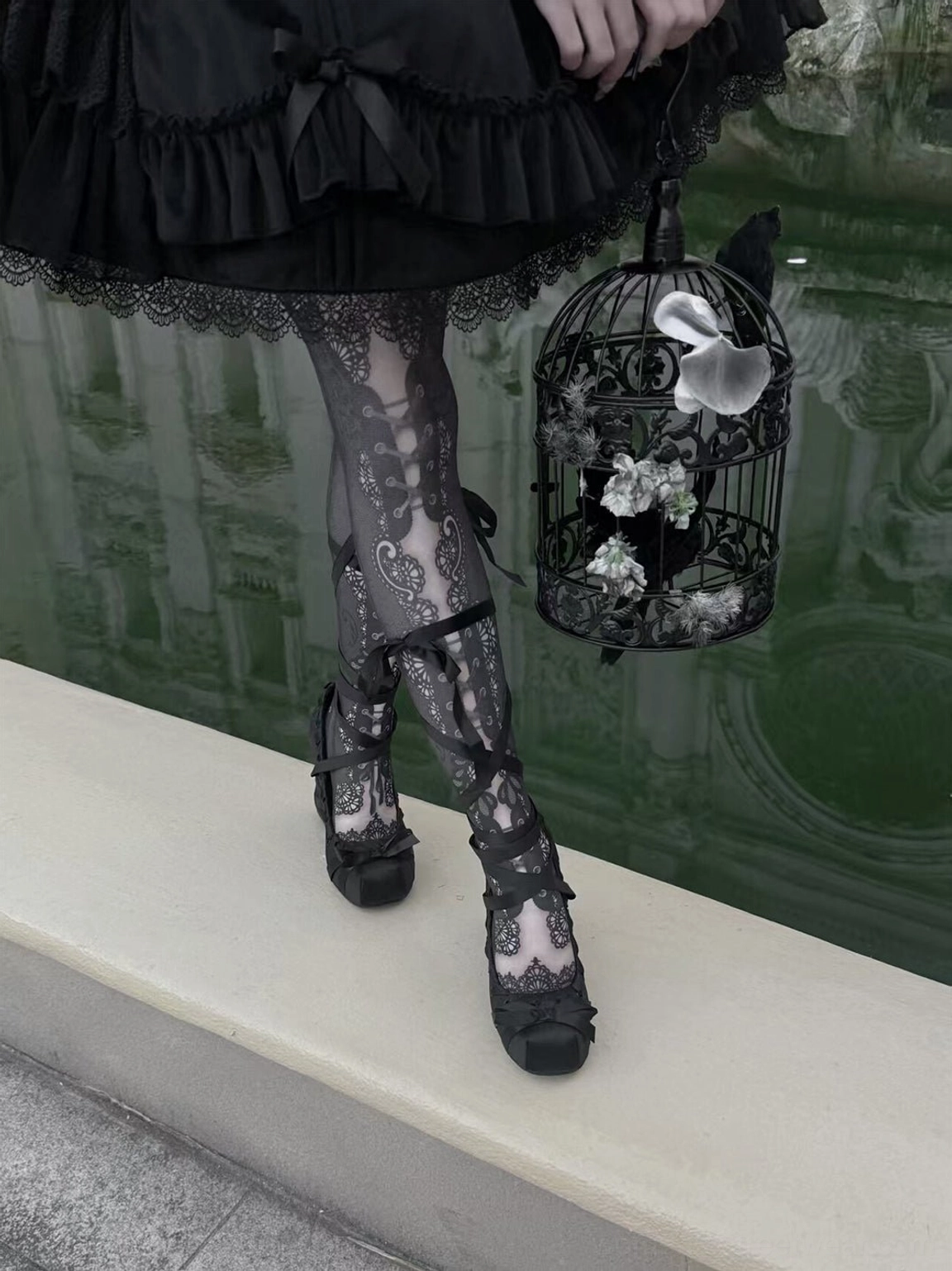 Black gothic satin platform pumps with lace toe cap and ankle ribbon ties styled with gothic Lolita dress and lace tights outdoors